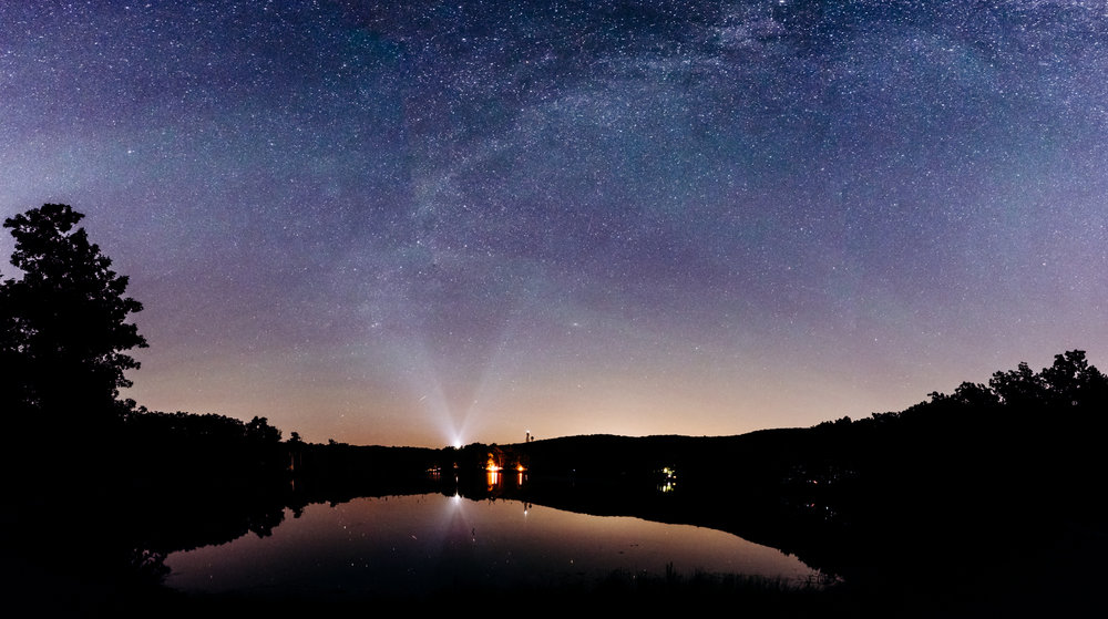 Light pollution is present even in some of the darkest parts of my home state of New Jersey. I was still able to capture a nice field of stars here by using 4 stitched vertical panoramic images using my favorite night photography lens, the Nikon 20mm f/1.8G