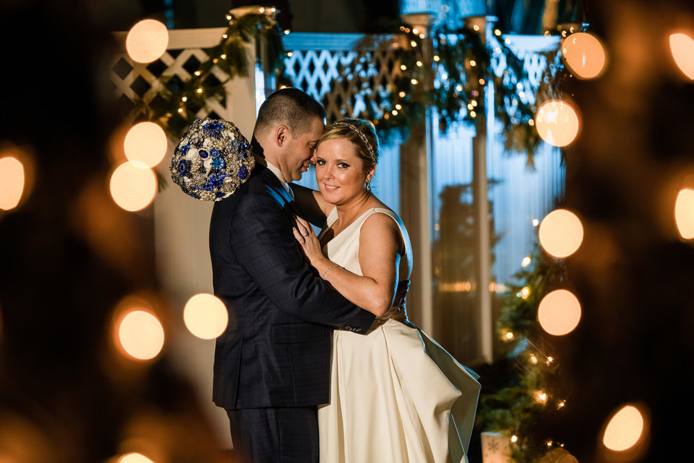Bride and groom during their winter wedding at the grain house in basking ridge new jersey with blue and orange Christmas themed lights