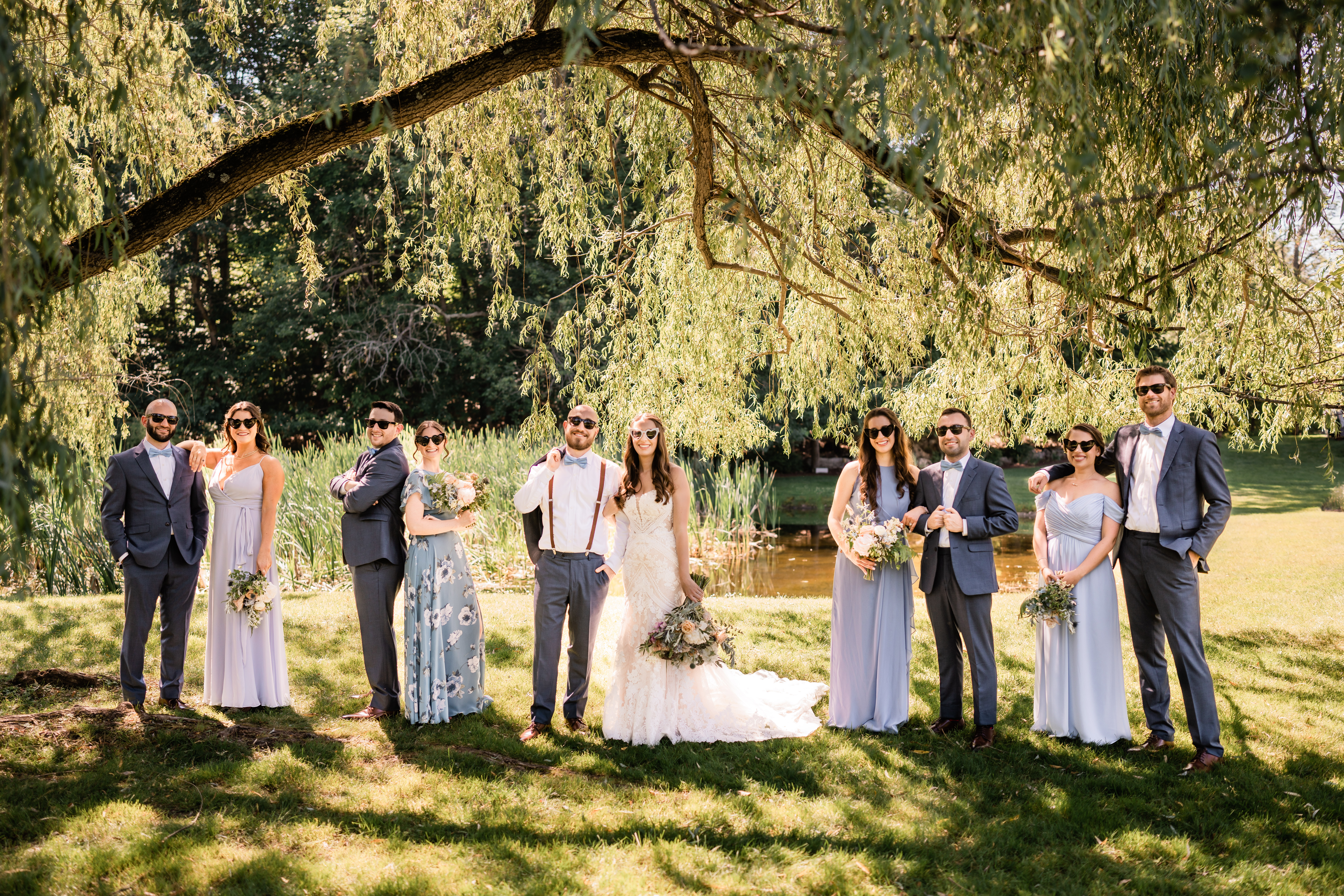 The Barn at Perona Farms, Perona Farms Wedding, New Jersey Wedding Photographer, Sussex County Wedding Photographer, NJ Wedding Photographer, Sussex County NJ Photographer, New Jersey Wedding Venues, Sussex County Wedding Venue, Wedding Inspiration, Wedding Planning, Wedding Ideas, Unique Wedding Photos, Wedding Photo Ideas, Boho Wedding, Farm Wedding, wedding party posed and smiling with sunglasses on under a willow tree at Perona Farms