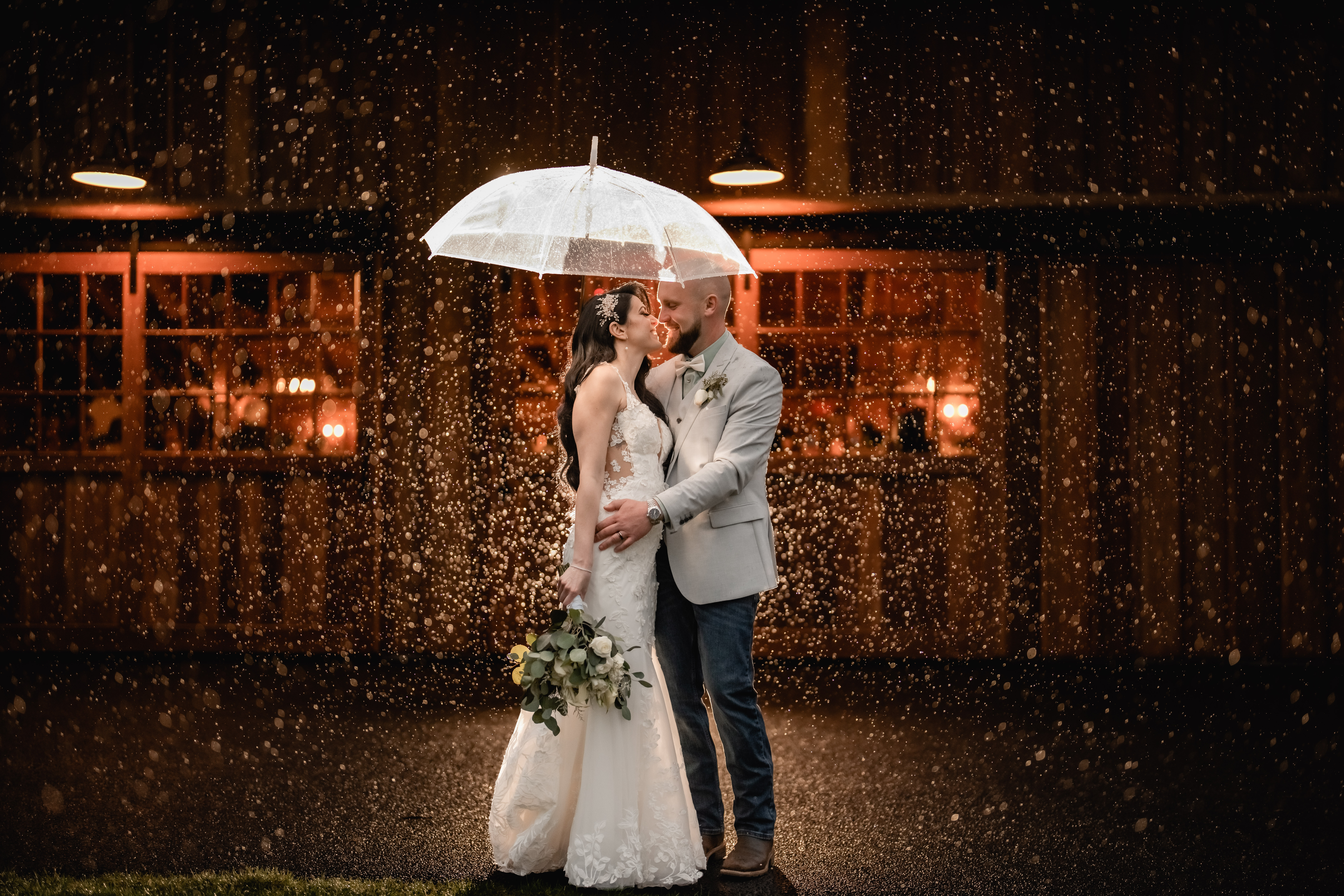 New Jersey Wedding Photographer, Rainy Day Wedding Photographer, New Jersey Wedding Venues, NJ Wedding Photographer, Unique Wedding Ideas, New Jersey Creative Photographer, Modern Wedding Couple, Wedding Inspiration, Wedding, photo of bride and groom smiling at each other under a clear umbrella while the rain and them are being back lit by a warm light