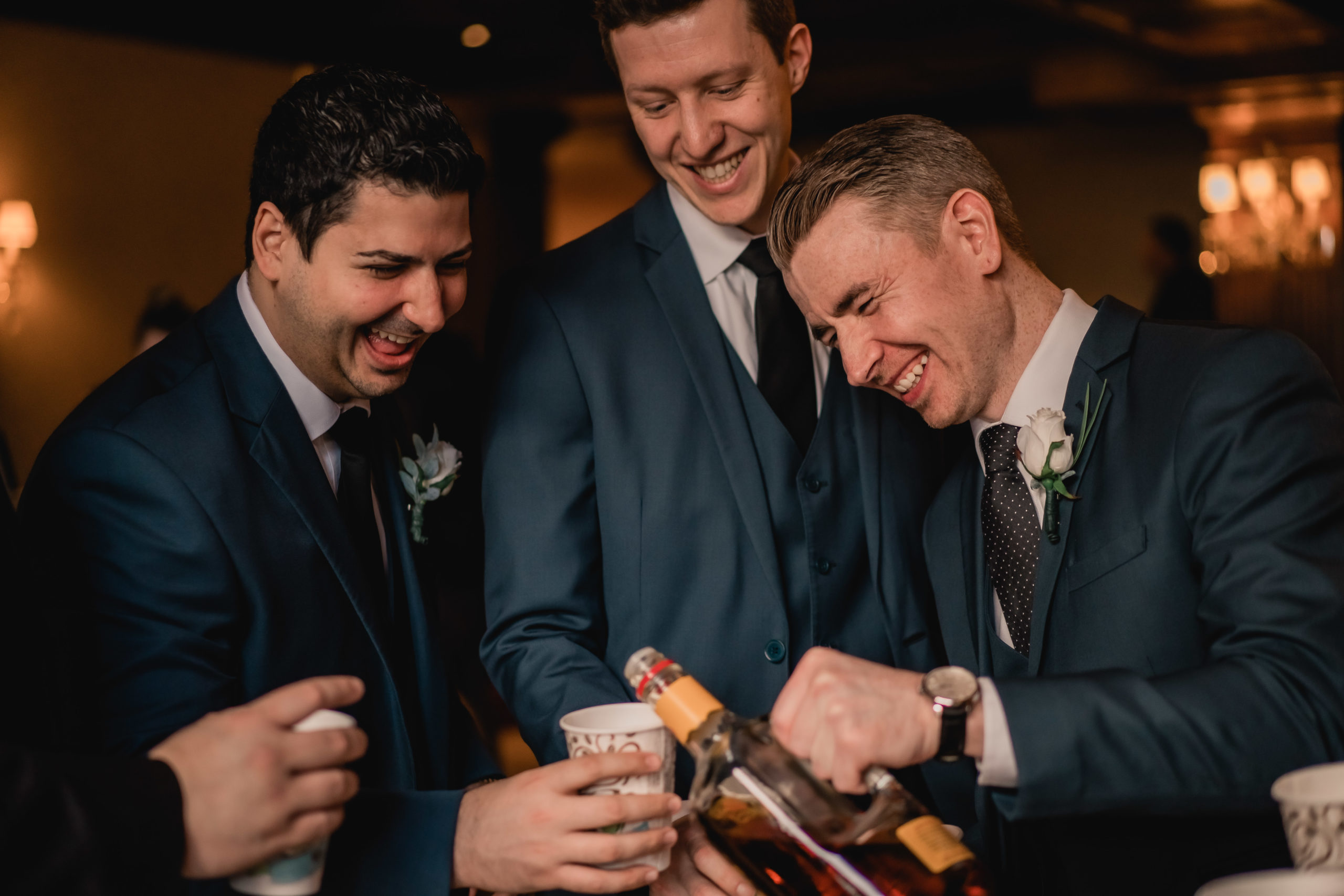 New Jersey Wedding Photographer,The Madison Hotel Wedding, The Madison Hotel Wedding Photographer, New Jersey Wedding Venues, NJ Wedding Photographer, Unique Wedding Ideas, The Madison Hotel Morristown NJ, Modern Wedding Couple, Wedding Inspiration, Wedding Planning, Morristown Wedding Photographer, Summer Wedding, Morristown NJ Photographer, candid photo of a groom pouring himself and his groomsmen a drink while laughing before the wedding ceremony at the madison hotel in morristown 