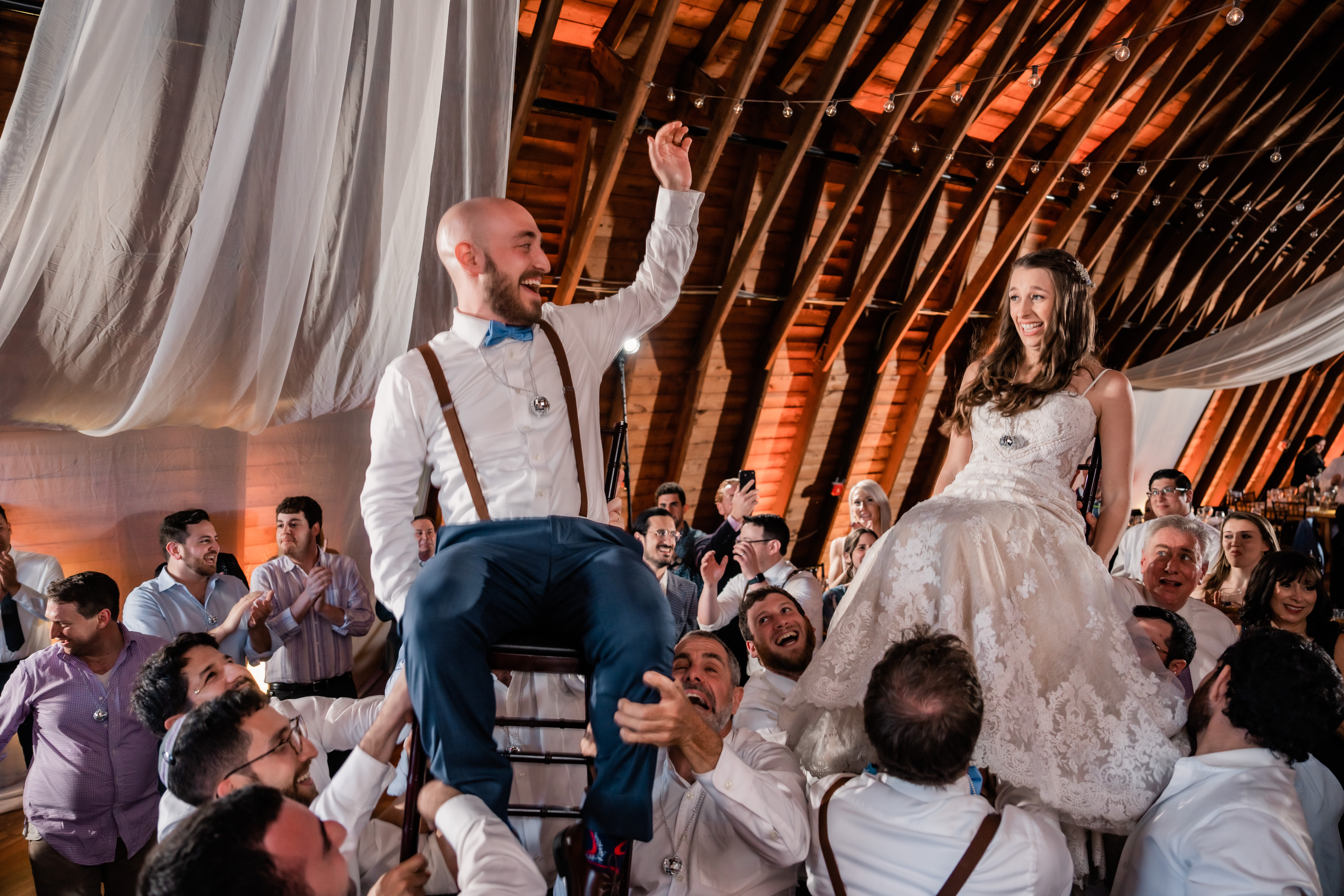 The Barn at Perona Farms, Perona Farms Wedding, New Jersey Wedding Photographer, Sussex County Wedding Photographer, NJ Wedding Photographer, Sussex County NJ Photographer, New Jersey Wedding Venues, Sussex County Wedding Venue, Wedding Inspiration, Wedding Planning, Wedding Ideas, Unique Wedding Photos, Wedding Photo Ideas, Boho Wedding, Farm Wedding, Bride and groom being carried up in chairs by guests during the reception