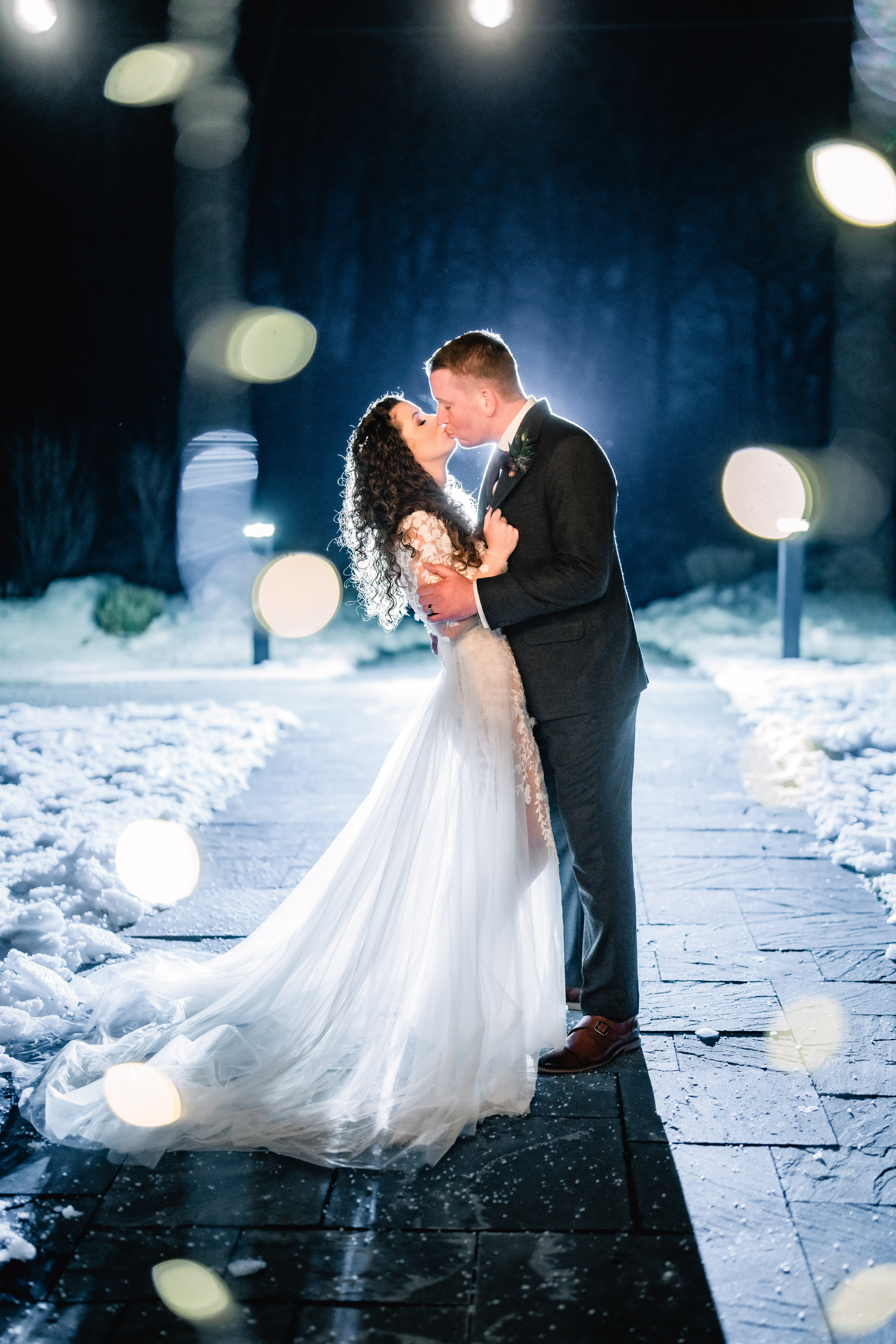 Rock Island Lake Club Wedding, Rock Island Lake Club Wedding Photographer, NJ Weddings, New Jersey Wedding Photographer, Sparta Wedding Photographer, NJ Wedding Photographer, Sussex County NJ  Photographer, New Jersey Wedding Venues, Sussex County Wedding Photography, NJ Winter Wedding, bride and groom kissing outside while surrounded by snow while being backlit by a flash 