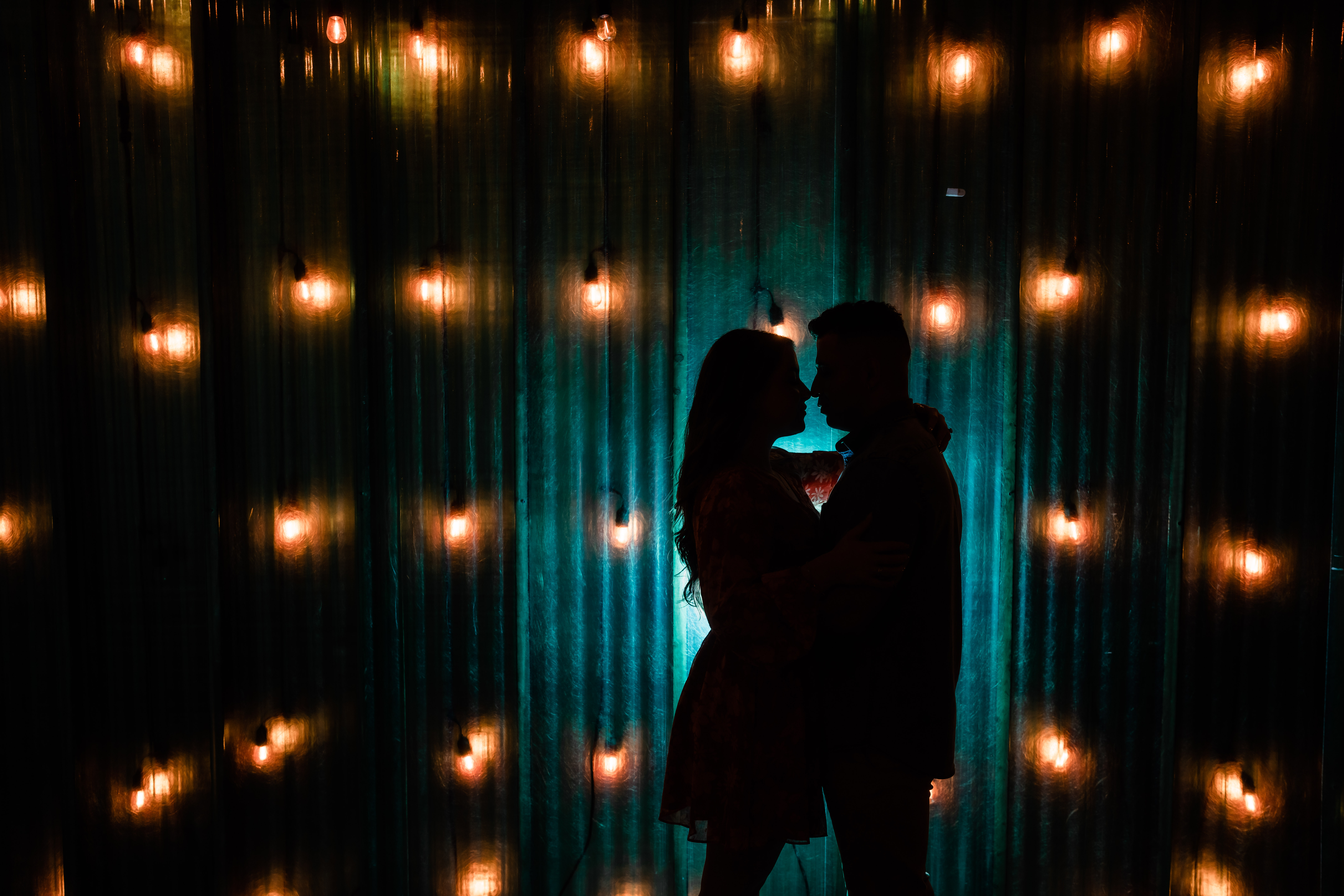 Art Factory Engagement, Art Factory Photographer, Art Factory Engagement Photographer, NJ Engagement Photographer, silhouette photo of couple nose to nose while there are fluorescent  lightbulbs surrounding them at the art factory