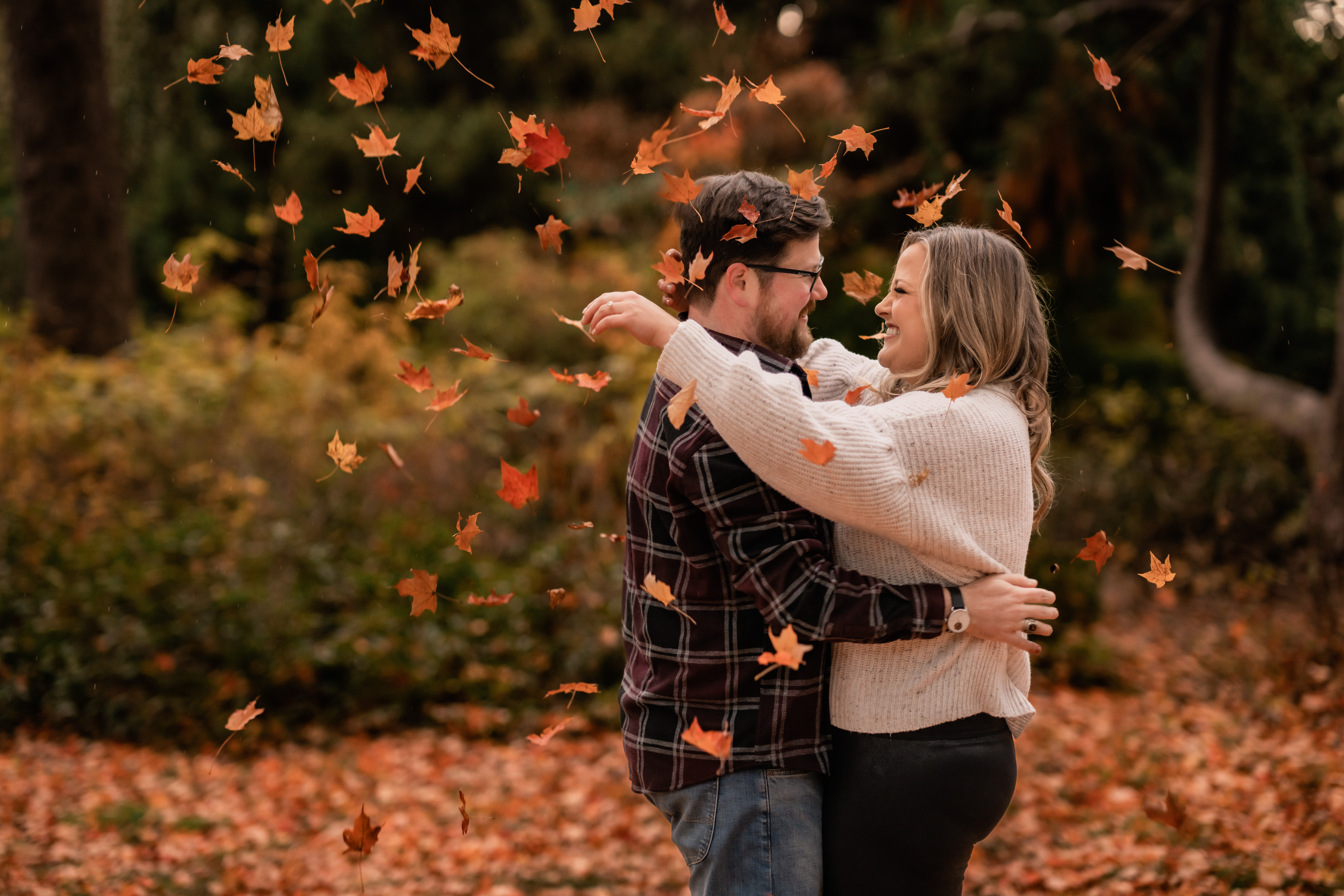 Skylands Manor Engagement Session, Skylands Manor Engagement Photographer, NJ Engagement Photographer, NJ Wedding Photographer, couple is smiling and hugging while the autumn leaves are falling around them 