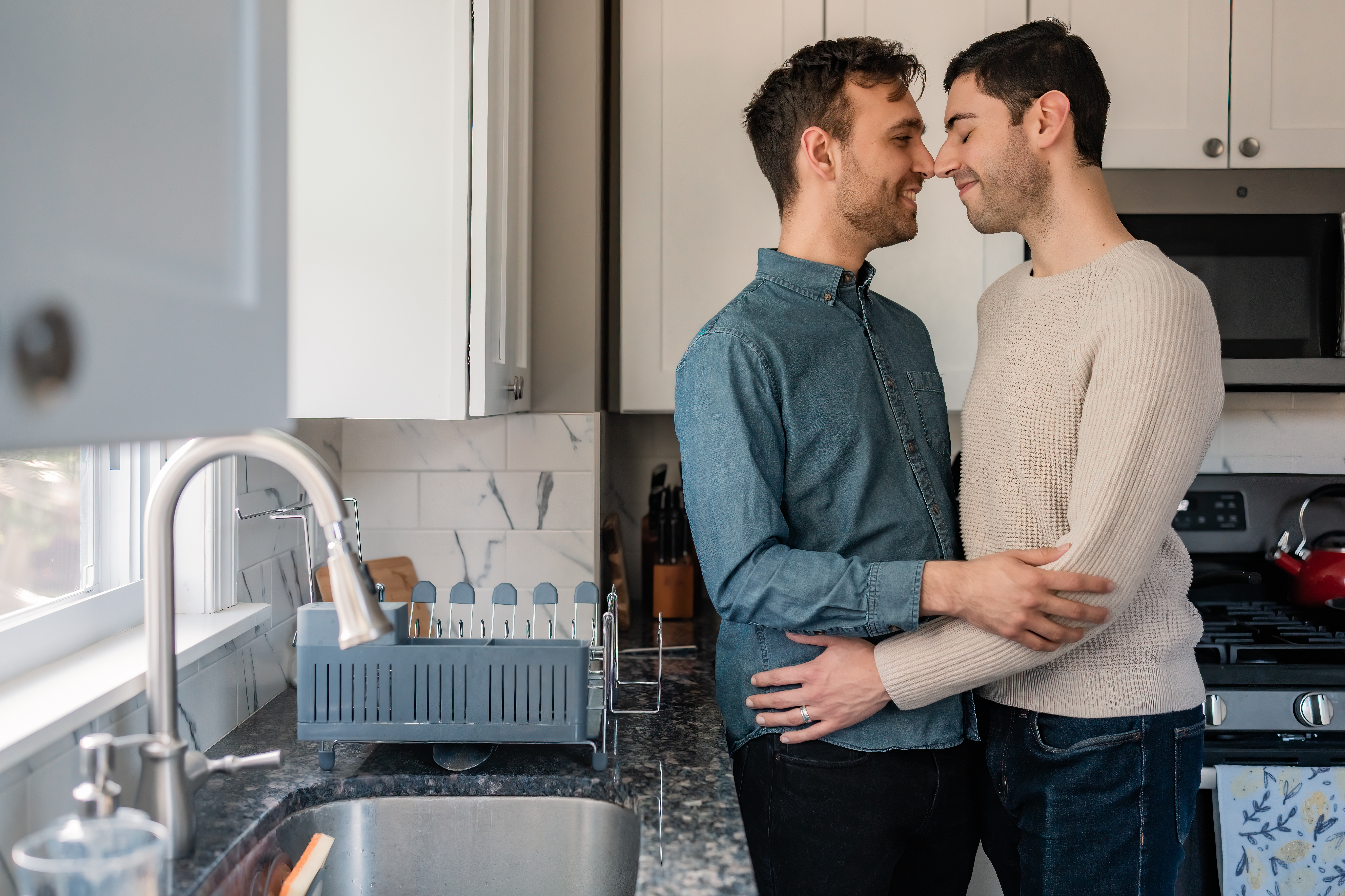 New Jersey Wedding Photographer, New Jersey Engagement Session, NJ Engagement Session, North Jersey Wedding Photographer, New Jersey Wedding Venues, NJ Wedding Photographer, Unique Wedding Ideas, LGBTQ Engaged Couple, Modern Wedding Couple, Wedding Inspiration, Wedding Planning, Engaged LGBTQ Couple in New Jersey smiling while nose to nose as they are hanging out in the kitchen at their house