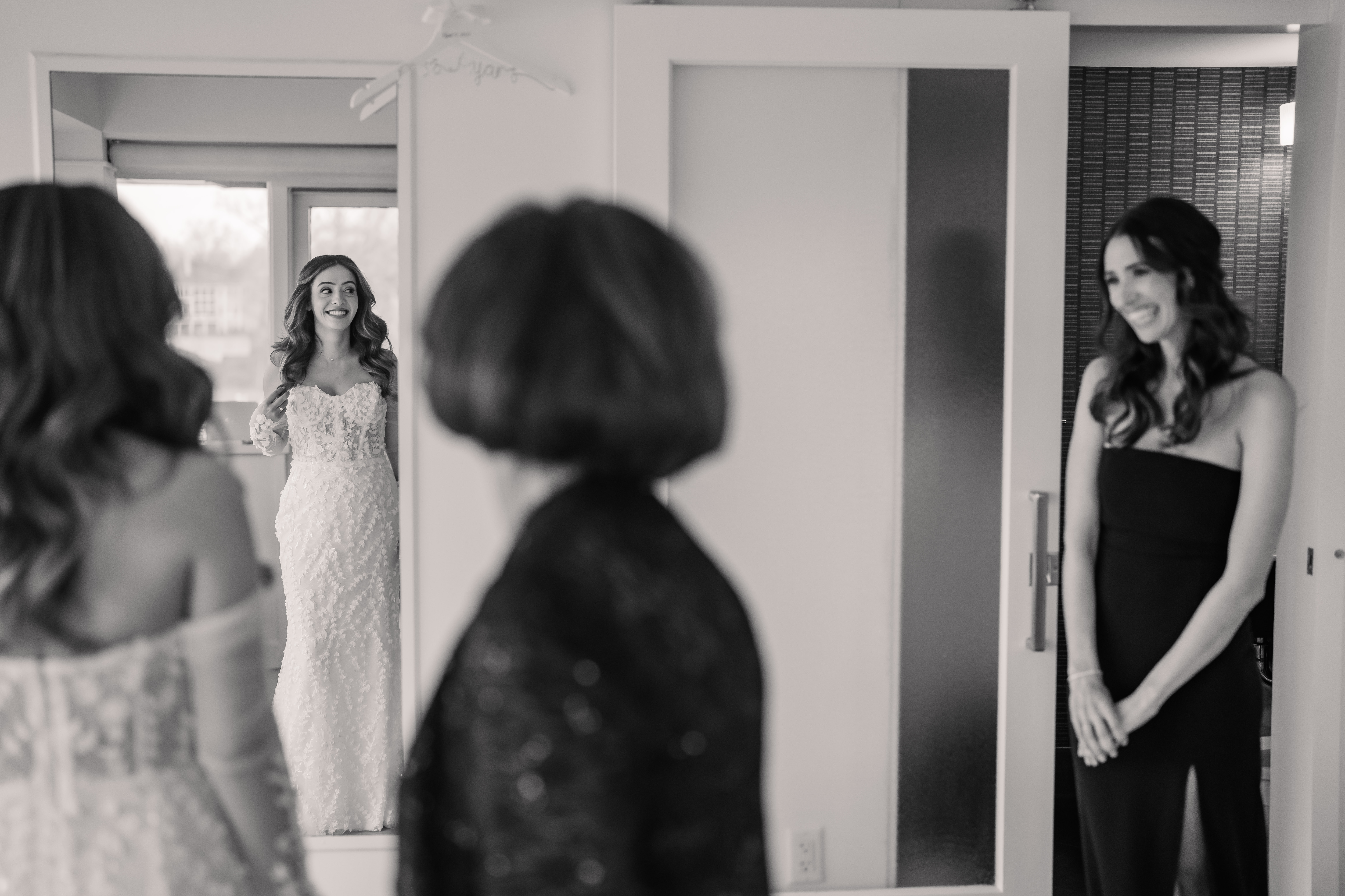 Emotional black-and-white New Jersey wedding photo of the bride revealing her wedding dress to family before the Park Loft ceremony.