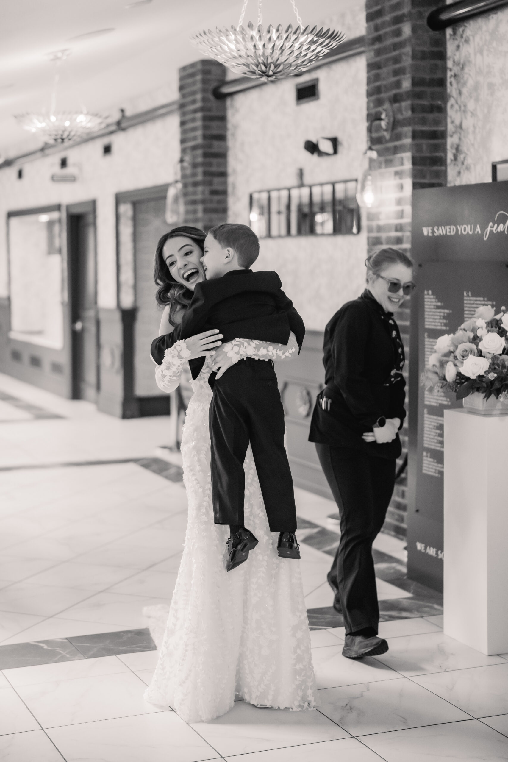 Candid Park Loft wedding photography in Oceanport, NJ, showing the bride laughing while holding a young ring bearer before the ceremony.