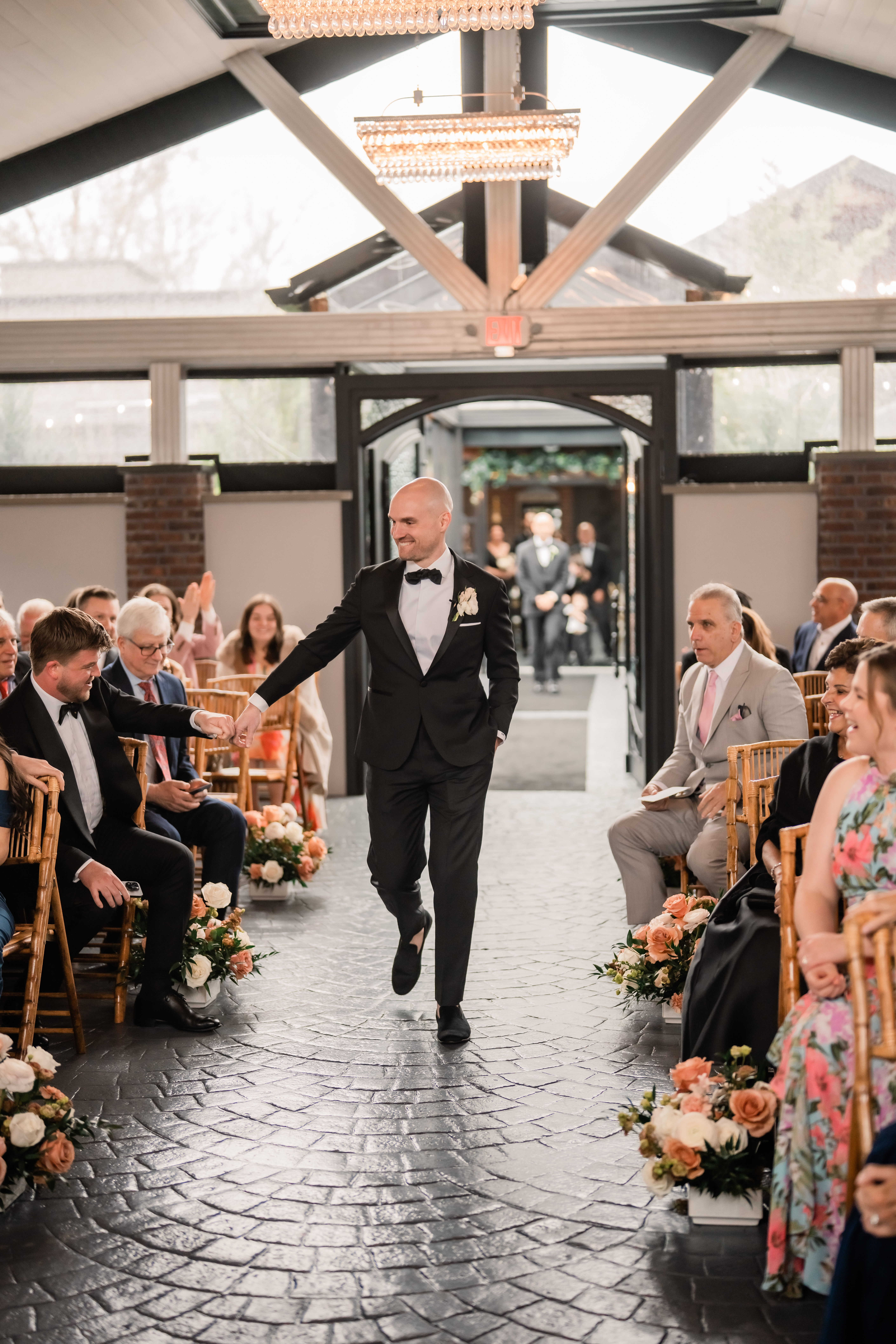 Park Loft wedding ceremony in Oceanport, NJ, with the groom walking down the aisle and greeting guests inside the Belvedere.