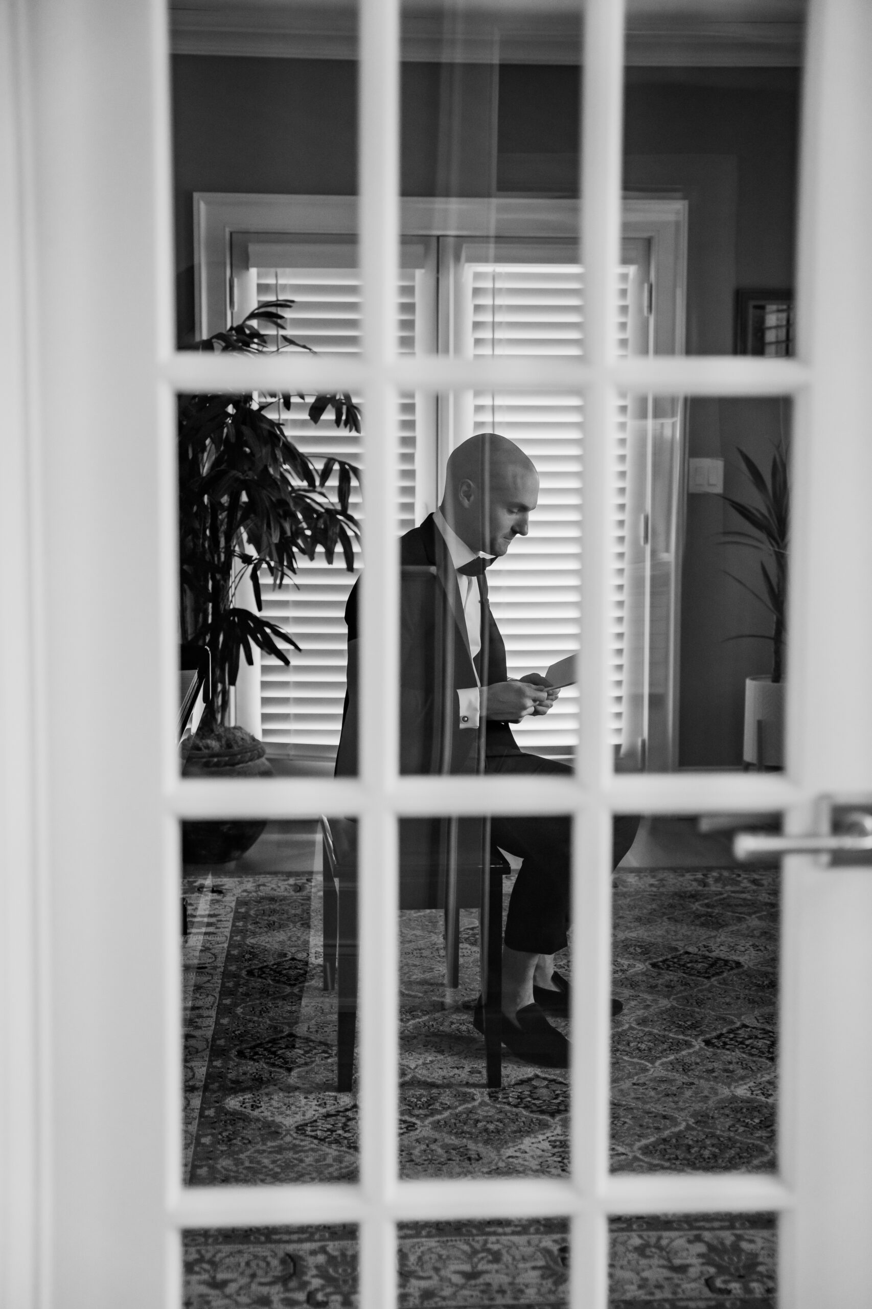Black-and-white New Jersey wedding photography showing the groom quietly reading a letter before his Park Loft wedding ceremony.