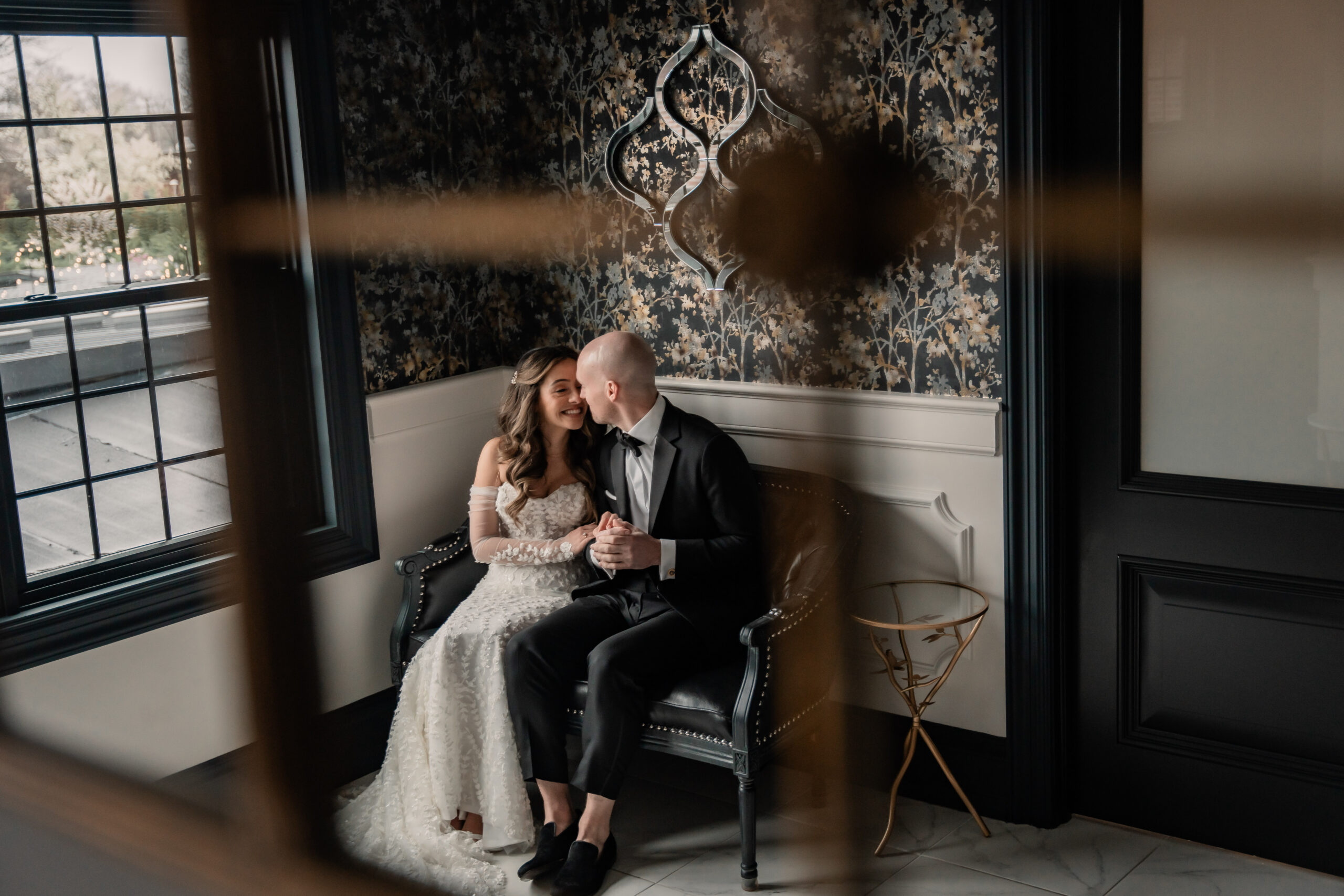 Park Loft wedding photography in Oceanport, NJ, featuring Bri and Dave sharing a quiet candid moment together on a dark leather bench inside the venue.