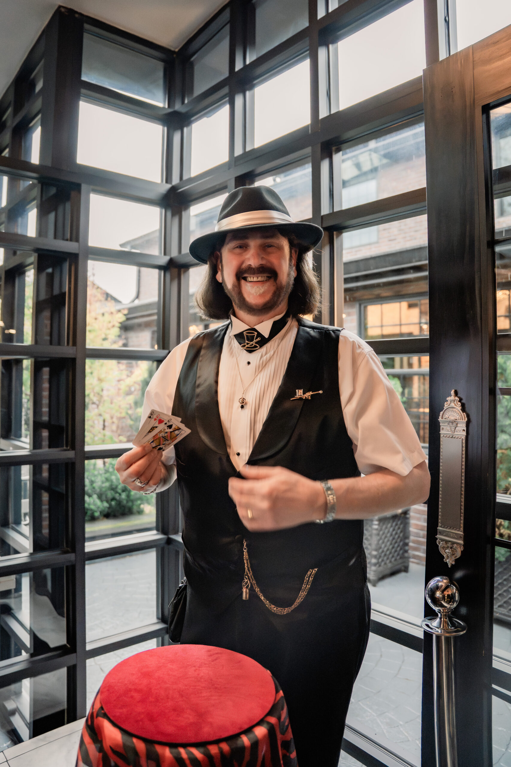 Park Loft wedding cocktail hour entertainment in Oceanport, NJ, featuring a strolling magician performing card tricks for guests.