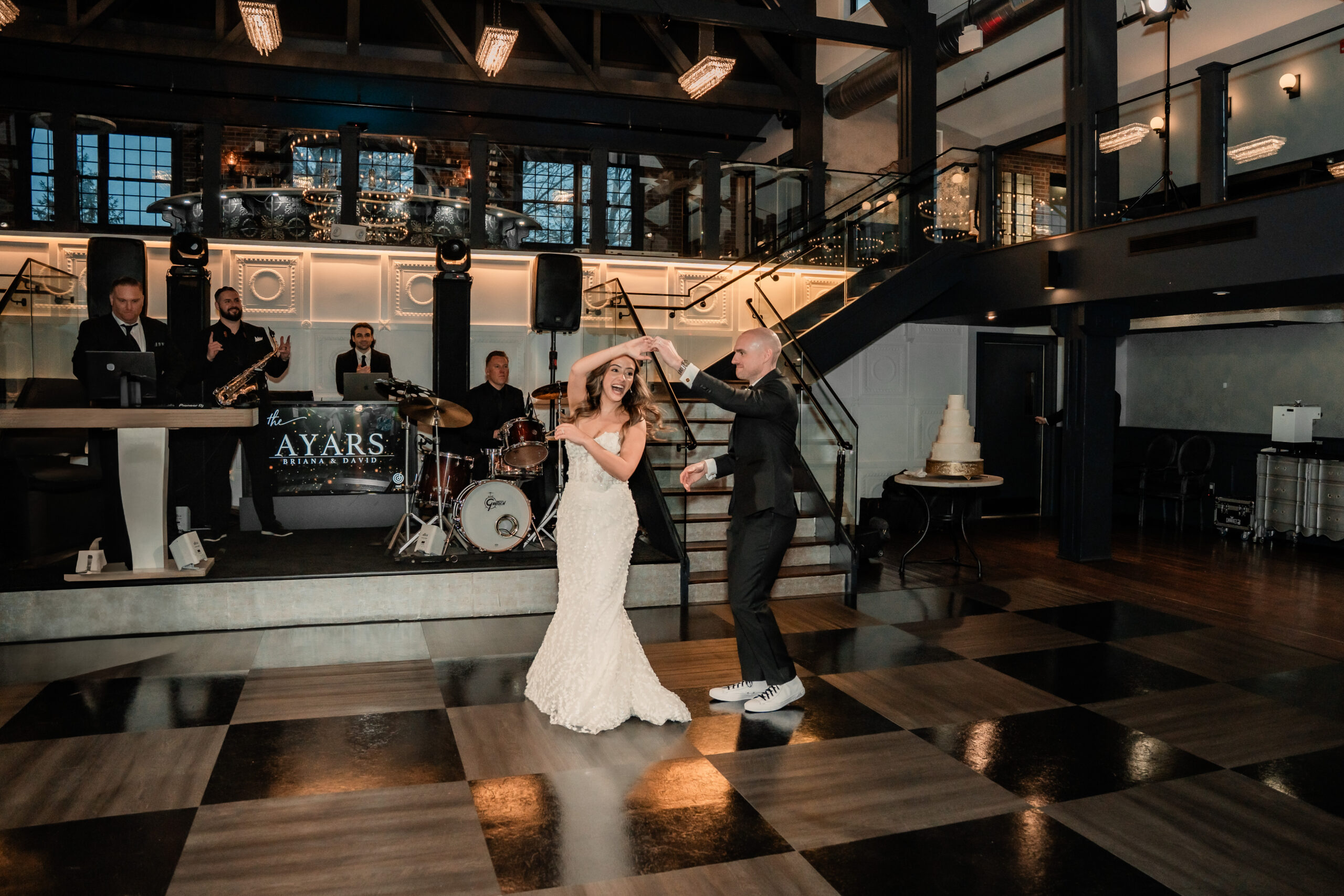 Park Loft wedding first dance in Oceanport, NJ, with the groom twirling the bride across the venue’s dramatic ballroom dance floor.