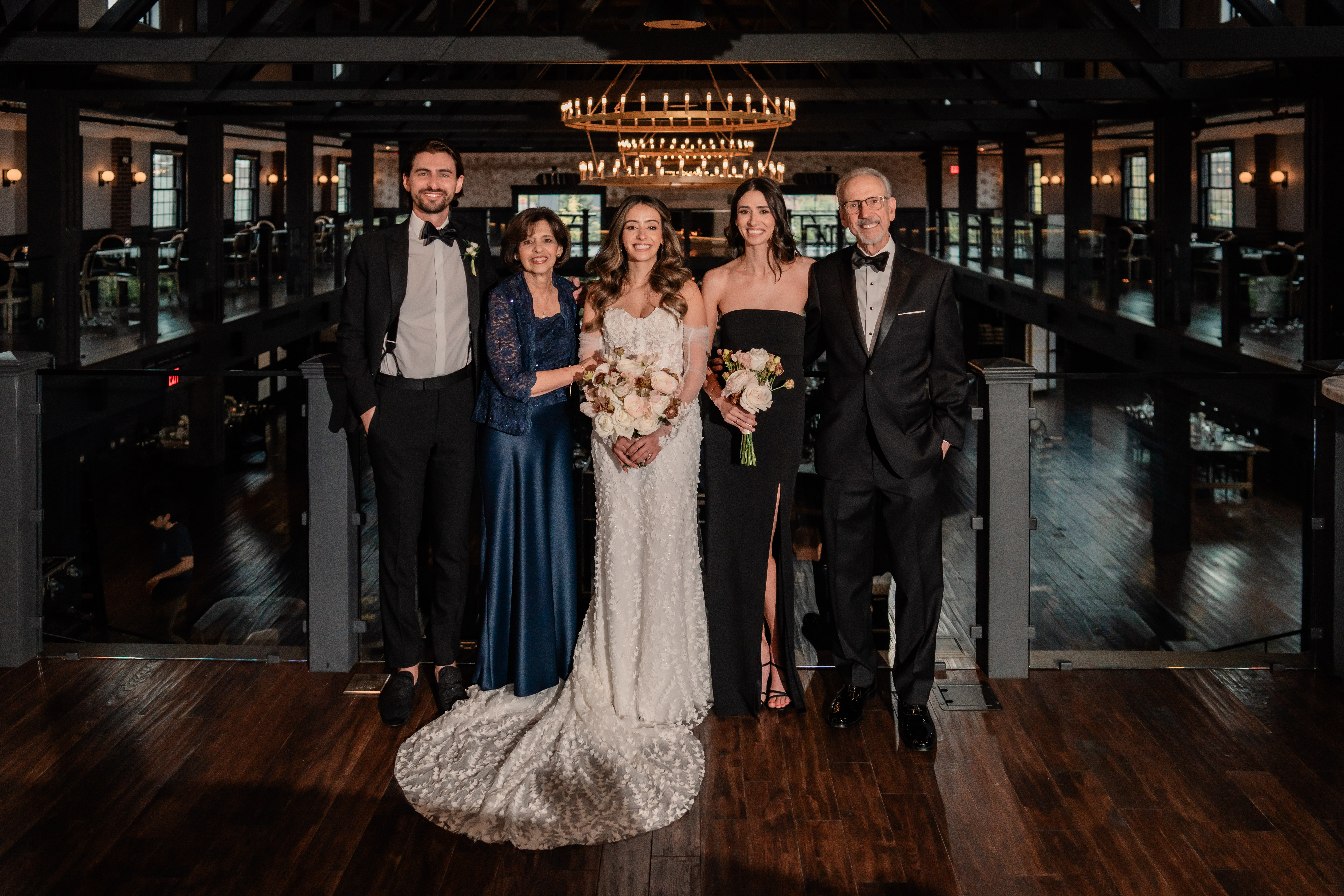 Park Loft wedding family portrait in Oceanport, NJ, photographed on the venue’s dramatic upper-level balcony overlooking the ballroom.