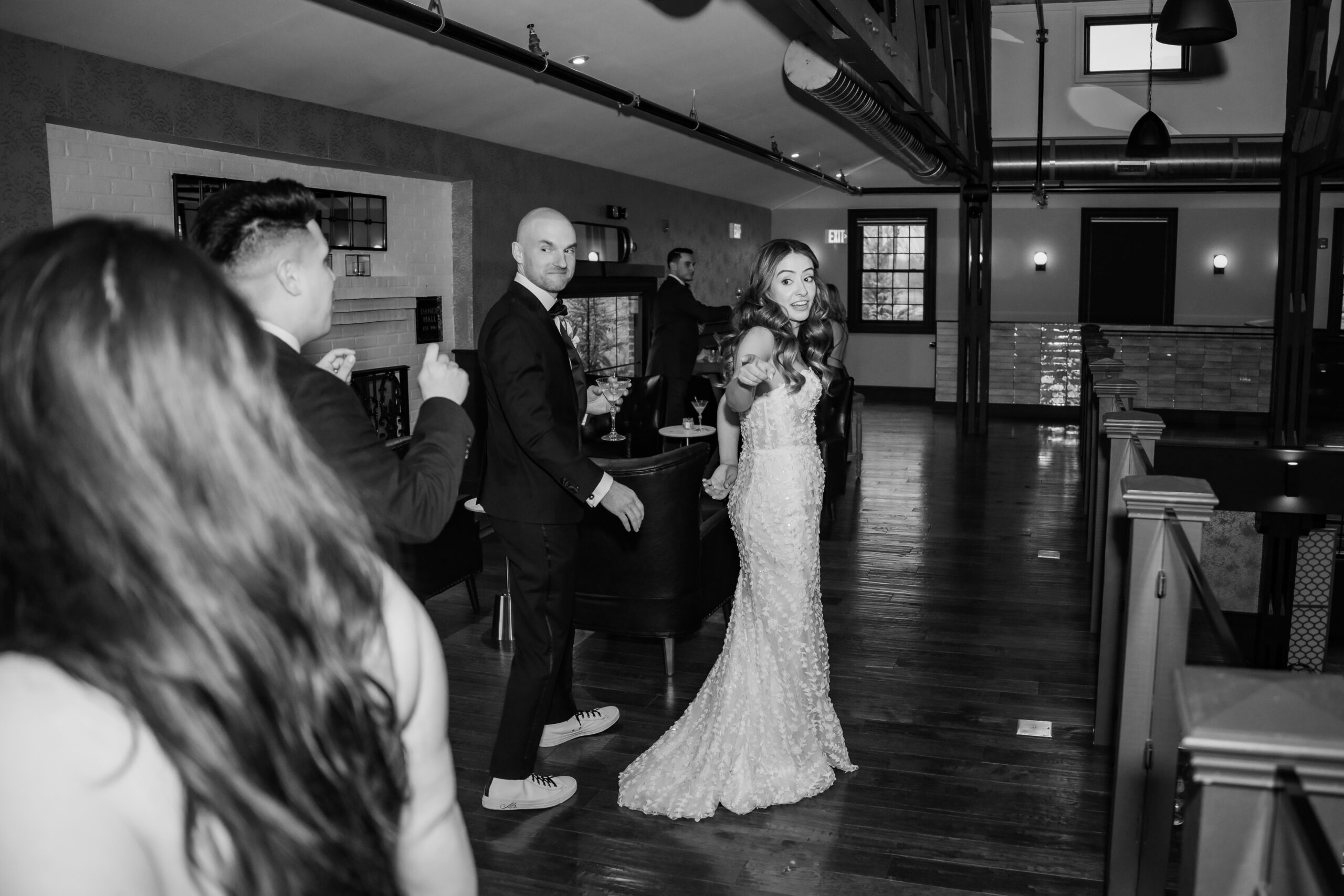 Black-and-white candid Park Loft wedding photography showing the newlyweds greeting guests during cocktail hour inside the Oceanport, NJ venue.