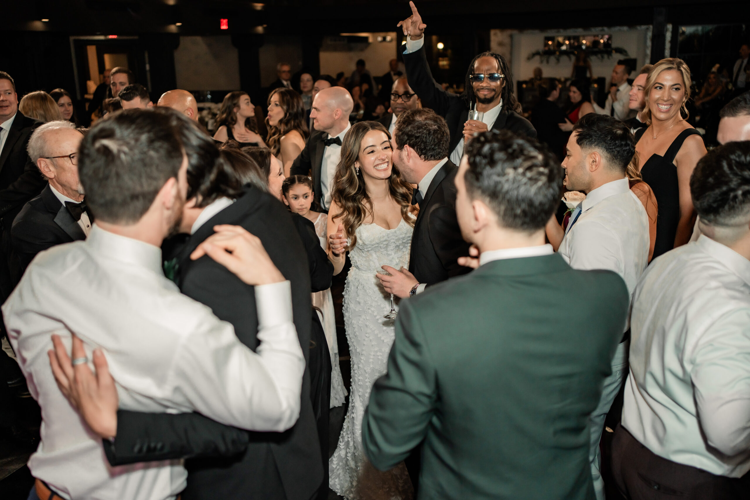Energetic New Jersey wedding photography at Park Loft, capturing the bride smiling in the middle of a crowded dance floor during the reception.