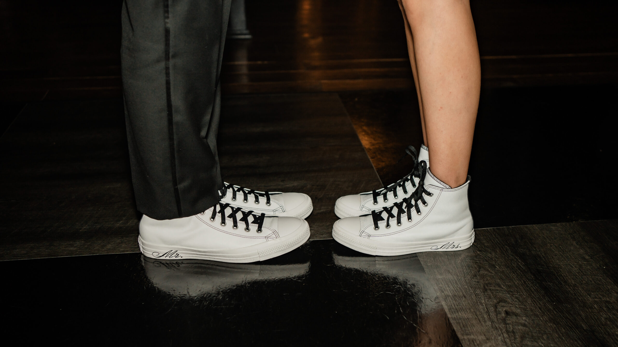Playful Park Loft wedding detail photo showing the bride and groom wearing matching white sneakers on the dance floor.