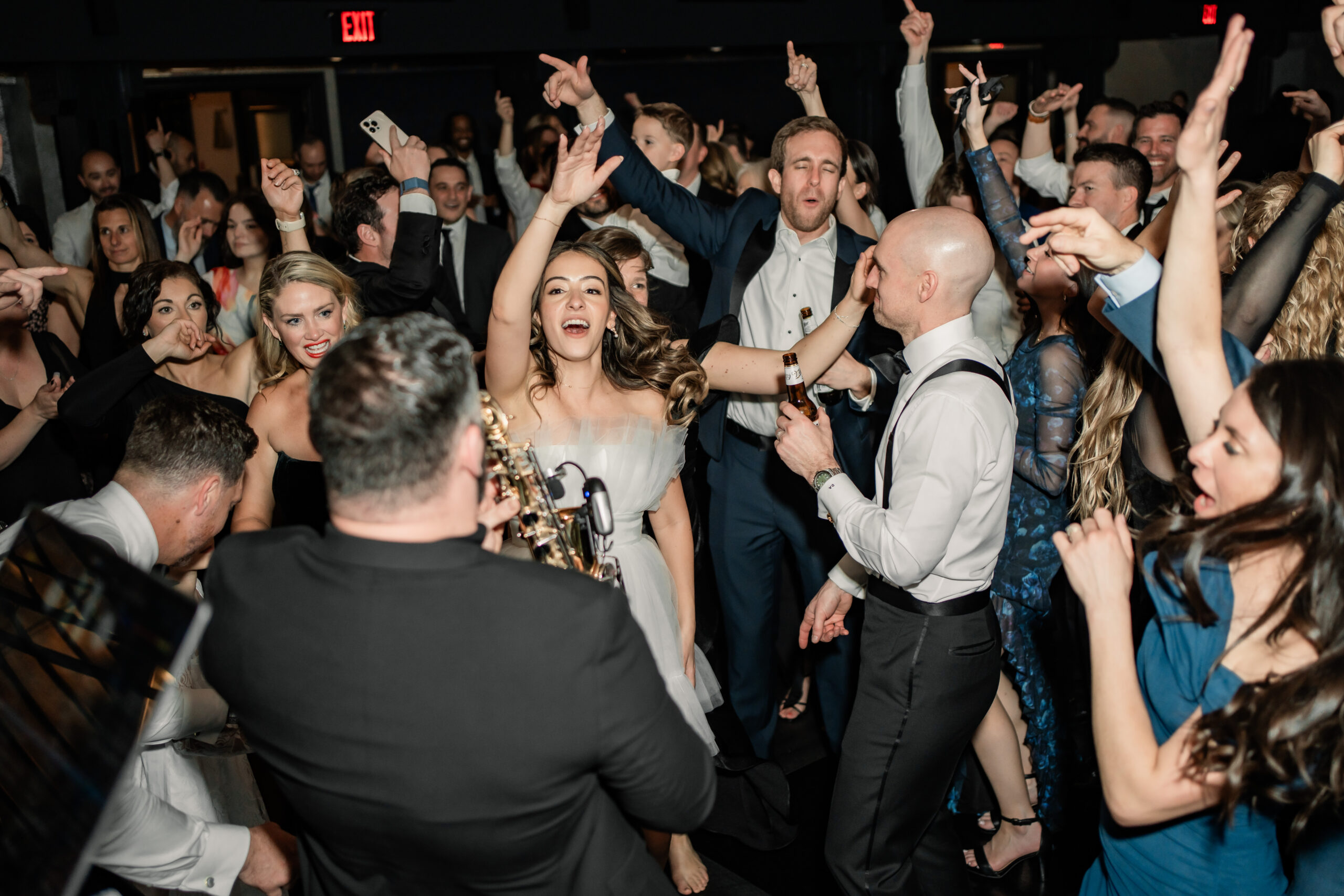 Energetic New Jersey wedding photography at Park Loft, with the bride dancing in the center of a packed crowd of family and friends.